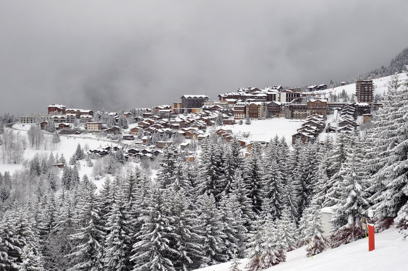 Courchevel Moriond (1650) seen through snowy trees from Courchevel Village
